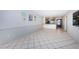 Open floor plan living room with neutral wall paint, ceramic tiled floor, and access to the kitchen at 9214 Mission Oaks Blvd, Seminole, FL 33776