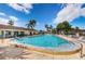 This is a community pool on a beautiful sunny day with trees and a building in the background at 9214 Mission Oaks Blvd, Seminole, FL 33776