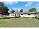 Beige single-story home with arched gated entry and a well-manicured front lawn at 1006 Mandalay Dr, Brandon, FL 33511