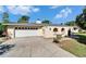 Beige single-story home featuring a two-car garage and arched gated entry at 1006 Mandalay Dr, Brandon, FL 33511