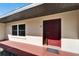 Exterior shot of red front door with covered entry and window to the side at 1006 Mandalay Dr, Brandon, FL 33511