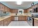 A well-lit kitchen showcasing wood cabinets, a stainless steel dishwasher, and a matching stainless oven at 1006 Mandalay Dr, Brandon, FL 33511