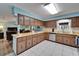 Traditional kitchen featuring wood cabinets, light countertops, white tile floors, and stainless steel dishwasher at 1006 Mandalay Dr, Brandon, FL 33511
