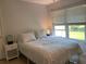 Charming bedroom with a queen bed, two windows, and side tables at 10351 Regal Dr # 18, Largo, FL 33774