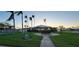 Clubhouse surrounded by green lawns, sidewalks, and palm trees with the US flag on display at 10351 Regal Dr # 18, Largo, FL 33774