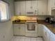 Well-lit kitchen featuring a stove, microwave, and ample cabinet space at 10351 Regal Dr # 18, Largo, FL 33774