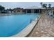 Large community swimming pool with lounge chairs and lush landscaping at 10351 Regal Dr # 18, Largo, FL 33774