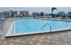 Large community swimming pool surrounded by chairs and lush landscaping at 10351 Regal Dr # 18, Largo, FL 33774