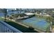 Overhead view of the community tennis courts with lush landscaping and waterfront views creating a serene playing experience at 10351 Regal Dr # 18, Largo, FL 33774