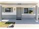 Close-up of the front of the home with a freshly painted front door and covered porch at 10686 110Th Ln, Largo, FL 33778