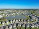 Wide aerial shot showcasing the expansive residential community with scenic lake and natural surroundings at 10727 Penny Gale Loop, San Antonio, FL 33576