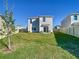 Spacious backyard with lush green lawn, a privacy fence, and a patio area with chairs, perfect for outdoor enjoyment at 10727 Penny Gale Loop, San Antonio, FL 33576