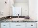 Bathroom vanity has a white sink, granite countertop, modern faucet and white cabinets with bronze pulls at 10727 Penny Gale Loop, San Antonio, FL 33576