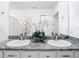 Bathroom with granite countertop, double sinks, a large mirror and white cabinets at 10727 Penny Gale Loop, San Antonio, FL 33576