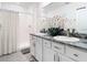 Bathroom featuring double sinks, granite counters, modern fixtures and walk-in shower at 10727 Penny Gale Loop, San Antonio, FL 33576