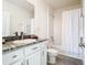The full bathroom has a granite countertop, white cabinets and a shower/tub combo with a white shower curtain at 10727 Penny Gale Loop, San Antonio, FL 33576