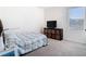 Cozy bedroom featuring a comfortable bed, storage unit, and a bright window creating a peaceful retreat at 10727 Penny Gale Loop, San Antonio, FL 33576
