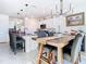 Bright open-concept dining area shows the modern chandelier, table with gray chairs, and connection to the kitchen at 10727 Penny Gale Loop, San Antonio, FL 33576