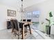 Dining room with wooden table and upholstered chairs, modern chandelier, and sliding doors to the outside at 10727 Penny Gale Loop, San Antonio, FL 33576