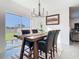 Light-filled dining room with modern chandelier, sliding glass doors, and table with seating at 10727 Penny Gale Loop, San Antonio, FL 33576