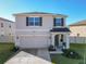 Two-story home featuring a manicured lawn, a two car garage, and welcoming front porch with attractive curb appeal at 10727 Penny Gale Loop, San Antonio, FL 33576