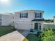 Inviting two-story home with a well-kept lawn, a two car garage, and cozy front porch with decorative plants at 10727 Penny Gale Loop, San Antonio, FL 33576