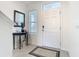 Inviting home foyer featuring neutral walls, ceramic flooring, and an accent table with decorative mirror at 10727 Penny Gale Loop, San Antonio, FL 33576