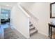 Hallway with stairs with white banister and gray carpet, next to a decorative table and mirror at 10727 Penny Gale Loop, San Antonio, FL 33576