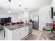 Kitchen features a granite island with seating, stainless appliances, and open floor plan to the living area at 10727 Penny Gale Loop, San Antonio, FL 33576