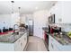 Kitchen boasts granite countertops, stainless appliances, white cabinetry, and an island with seating at 10727 Penny Gale Loop, San Antonio, FL 33576