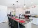 Open kitchen features granite countertops, stainless appliances, pendant lights, and an island with seating at 10727 Penny Gale Loop, San Antonio, FL 33576
