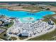 Aerial view of clear blue lagoon featuring a sandy beach, lounge seating, and aqua park at 10727 Penny Gale Loop, San Antonio, FL 33576