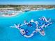 Aerial view of the lagoon showing the inflatable park with slides and other features for adventurous families at 10727 Penny Gale Loop, San Antonio, FL 33576