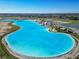 Wide-angle aerial image showcases an expansive lagoon, complete with beach, lounge area, and water park at 10727 Penny Gale Loop, San Antonio, FL 33576