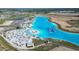 Aerial view of community lagoon featuring beach area, beach chairs, palm trees, and aqua park at 10727 Penny Gale Loop, San Antonio, FL 33576