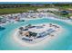 Aerial view of island in lagoon with lounge chairs, palm trees, and thatched umbrellas at 10727 Penny Gale Loop, San Antonio, FL 33576
