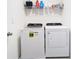 Bright laundry room featuring modern washer and dryer with overhead storage shelves at 10727 Penny Gale Loop, San Antonio, FL 33576