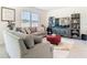 Comfortable living room with modern furniture, TV, shelves, and soft neutral colors and big window at 10727 Penny Gale Loop, San Antonio, FL 33576