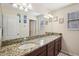 Bathroom with granite counters, double sinks, vanity lighting, and modern fixtures at 11056 Little Blue Heron Dr, Riverview, FL 33579