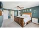 Spacious bedroom showcasing dark-green walls, plush carpet, and a wooden platform bed at 11056 Little Blue Heron Dr, Riverview, FL 33579