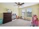 Well-lit bedroom featuring plush carpeting, ceiling fan, and plenty of room for fun and games at 11056 Little Blue Heron Dr, Riverview, FL 33579