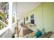 Cozy covered balcony with a swing, seating area, and vibrant decor for relaxation at 112 13Th Ave, Indian Rocks Beach, FL 33785