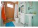 Compact bathroom featuring a pedestal sink, orange-tiled shower, and white vanity at 112 13Th Ave, Indian Rocks Beach, FL 33785