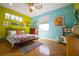 Bright bedroom featuring colorful walls and quilts, hardwood floors, and ample natural light at 112 13Th Ave, Indian Rocks Beach, FL 33785