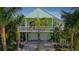 A two-story home with a two-car garage, a balcony and a beautifully landscaped yard with mature palms at 112 13Th Ave, Indian Rocks Beach, FL 33785