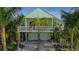 Beautiful two-story house with a balcony, surrounded by tropical foliage and a well-maintained yard at 112 13Th Ave, Indian Rocks Beach, FL 33785