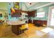 Stylish kitchen with an island, bar stools, wooden cabinets, stainless steel appliances and hardwood flooring at 112 13Th Ave, Indian Rocks Beach, FL 33785