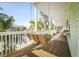 Comfortable porch with a swing and table with chairs, perfect for relaxing with friends and Gathering at 112 13Th Ave, Indian Rocks Beach, FL 33785