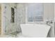 A modern bathtub and shower combination is showcased in this well lit bathroom at 12304 Silton Peace Dr, Riverview, FL 33579