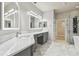Bright bathroom features double vanity, marble floors, and a walk-in shower with a modern shower system at 12304 Silton Peace Dr, Riverview, FL 33579